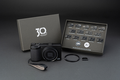 RICOH GR IV 30th Anniversary Edition Kit: fotocamera, confezione 30th Anniversary, 16 spille, cinturino in pelle, copriobiettivo ad anello e copri slitta