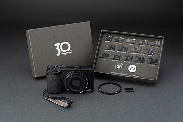 RICOH GR IV 30th Anniversary Edition Kit: fotocamera, confezione 30th Anniversary, 16 spille, cinturino in pelle, copriobiettivo ad anello e copri slitta